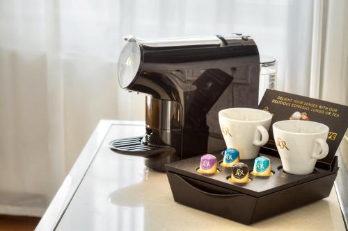 a coffee maker and two cups on a table at Black Star Suites in Prague
