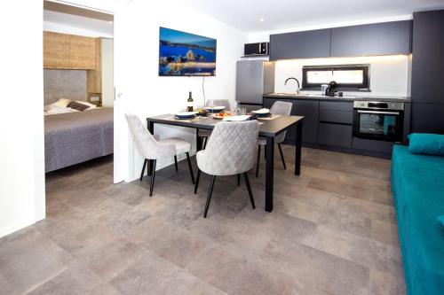 a kitchen and dining room with a table and chairs at Sea view Anika by Vellaris, Luxury Mobile Home in Mali Lošinj
