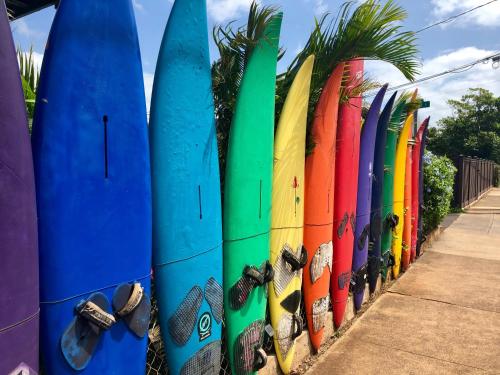 una fila de tablas de surf apoyadas contra una valla en Roxon Sea Sand Bat Yam, en Bat Yam