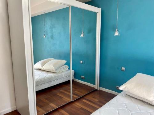 a mirror in a room with a bed and blue walls at Sublime 3 pièces Hyper Centre Ville de Nice in Nice