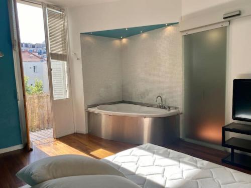 a large bathroom with a tub and a tv at Sublime 3 pièces Hyper Centre Ville de Nice in Nice