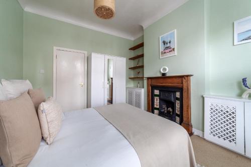 a bedroom with a white bed and a fireplace at The Finsbury Park Collection in London