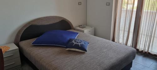 a bedroom with a bed with a blue pillow on it at Villa Karla B&B in Veli Iž