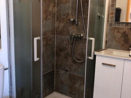 une salle de bain avec une douche avec une porte vitrée dans l'établissement Villa T4 pour 8 pers. à 350m de la plage avec 3 terrasses, parking privé et équipements complets - FR-1-81-415, à Port-Leucate