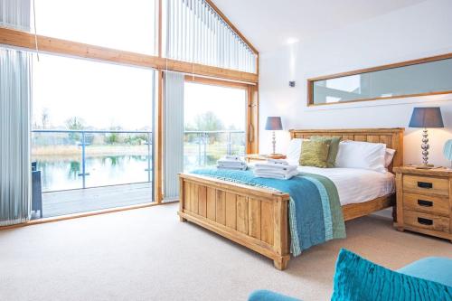 sypialnia z łóżkiem i dużym oknem w obiekcie Waters Edge 05, Amaranth Lodge - P w mieście South Cerney