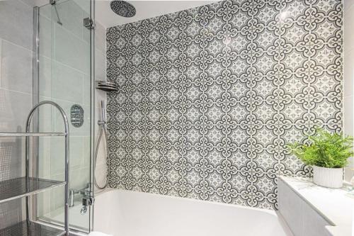 a bathroom with a shower and a bath tub with a tile wall at Windrush Lake 66, Sun Kissed Lodge in South Cerney