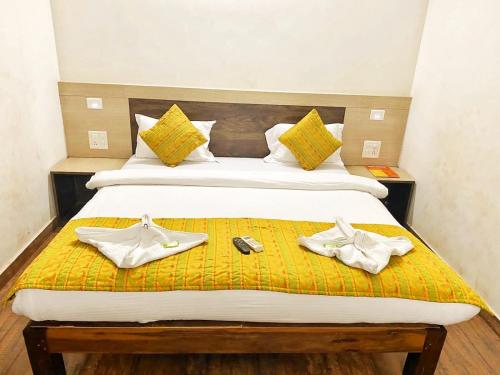 Un dormitorio con una cama con dos zapatos. en Baga Beach Inn en Baga