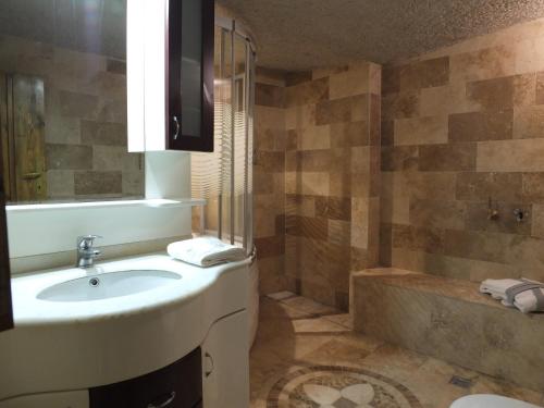 y baño con lavabo, ducha y bañera. en Anatolia cave hotel Pension, en Göreme