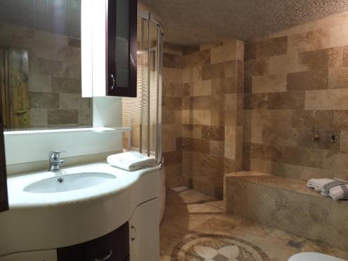 a bathroom with a sink and a shower and a tub at Anatolia cave hotel Pension in Goreme