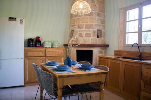 uma cozinha com uma mesa de madeira com tigelas azuis em Amygdalia Traditional House em Chania Town