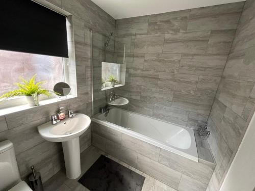 a bathroom with a sink and a tub and a toilet at The E17 Suite in London