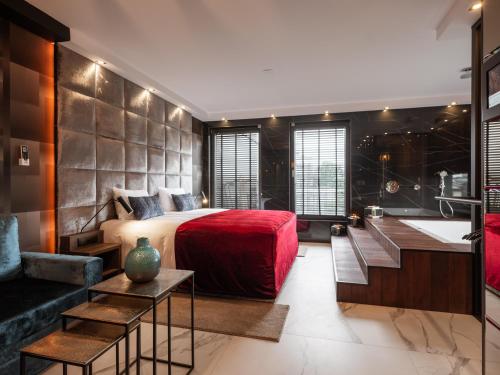 1 dormitorio con 1 cama grande con colcha roja en Art Suites Boutique Hotel - Krakow Center en Cracovia