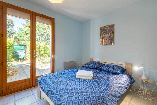 Un dormitorio con una cama azul y una ventana en Maison avec piscine et belle vue, en Lédenon