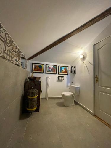 a bathroom with a toilet and pictures on the wall at Apartament Art Cluj in Cluj-Napoca