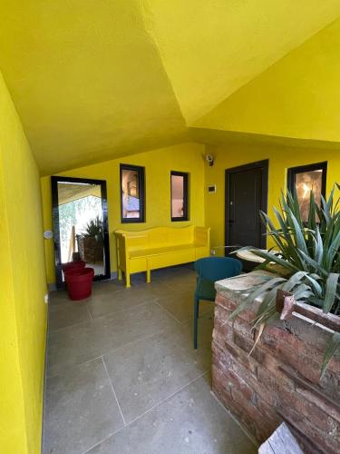 a yellow room with a yellow bench and a table at Apartament Art Cluj in Cluj-Napoca