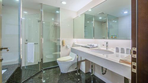 a bathroom with a toilet and a sink and a shower at CHECK inn SELECT Taichung Dadun in Taichung