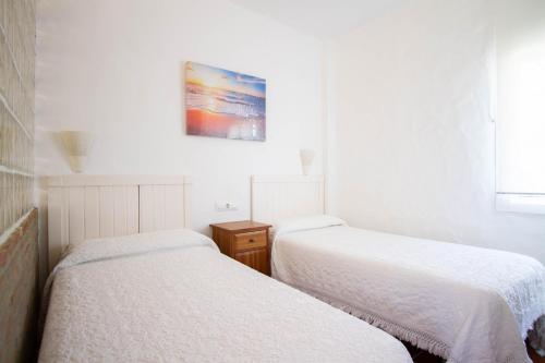 a bedroom with two beds and a painting on the wall at Apartamentos Turisticos Trajano in Bolonia