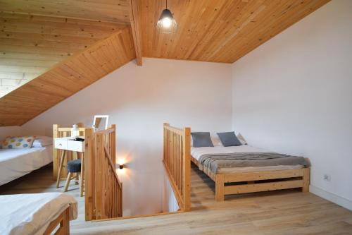 - une chambre avec deux lits et un plafond en bois dans l'établissement Redwood Mielno, à Mielno