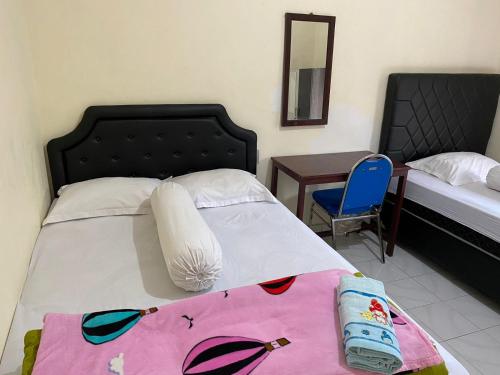 Bajawa的住宿－Mawar Bed and Breakfast，卧室配有1张床、1张桌子和1把椅子