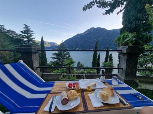 una mesa con dos platos de comida y vistas al lago en Prestine', en Nesso