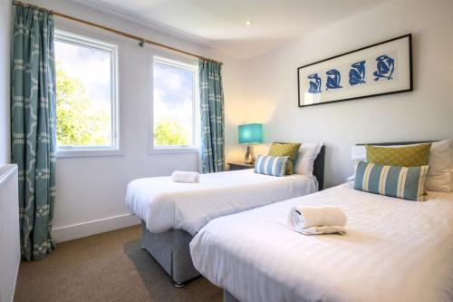 two beds in a room with two windows at The Landings 18, Waters Reach - P in South Cerney