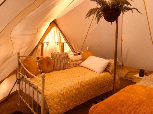 a bedroom with a bed in a tent at Rose glamping, self catering, bell tent in St Austell