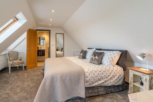 a bedroom with a large bed and a chair at Timber Lodge in Tackley