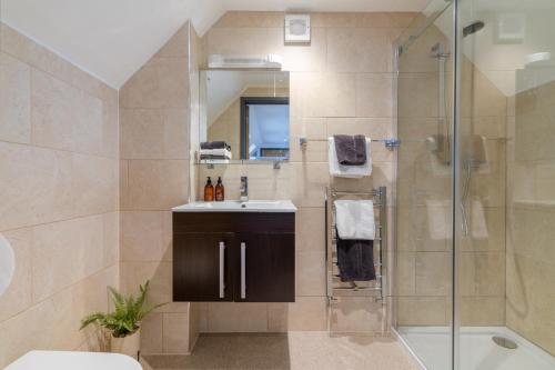 a bathroom with a shower and a sink and a mirror at Timber Lodge in Tackley