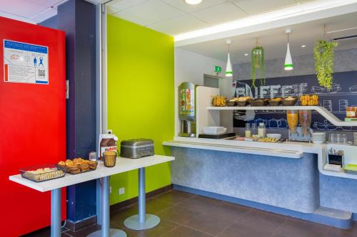 a fast food restaurant with yellow and green walls at Ibis Budget Grenoble Sud Seyssins in Seyssins