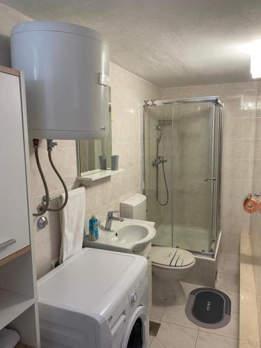 uma casa de banho com um chuveiro, um WC e um lavatório. em apartments Marina,Bikić em Marina