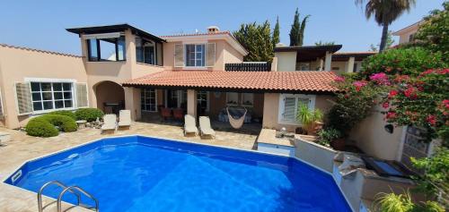 a swimming pool in front of a house at Villa Laonari in Tsadha