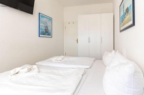 two beds in a room with white walls at Villa-Strandidyll-Typ-2 in Binz