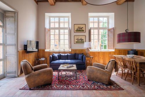 a living room with a blue couch and chairs at Le Domaine de Ravenoville - Pierres d'Histoire in Ravenoville