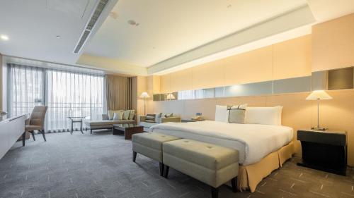 Habitación de hotel con cama y sala de estar. en CHECK inn SELECT Taichung Dadun, en Taichung