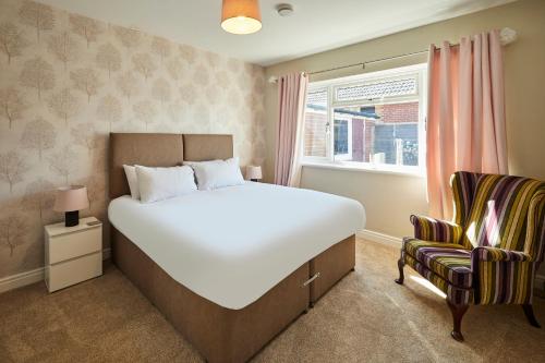 a bedroom with a large bed and a chair at Host & Stay - White Rose in Marske-by-the-Sea