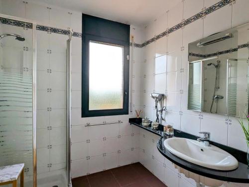 La salle de bains est pourvue d'un lavabo et d'un miroir. dans l'établissement Casa estrella, à Begur