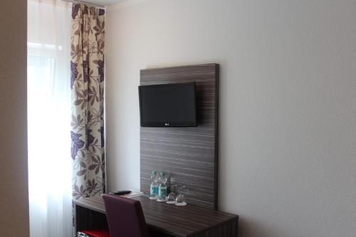 a room with a mirror with a tv on the wall at Altes Backhaus in Herzogenaurach