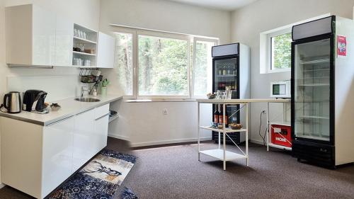 a kitchen with white cabinets and a large window at Treffpunkt Heuwiese in Weite