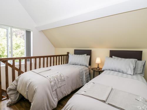 two beds sitting next to each other in a bedroom at The Old Post Office Barn in Welland