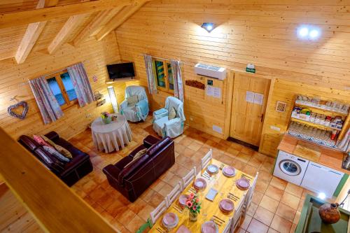 una vista aérea de una sala de estar en una cabaña de madera en Madera y Miel Casa Rural con niños en Puy du Fou, en Guadamur