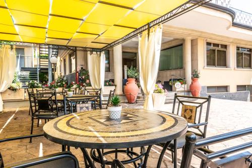 a patio with tables and chairs and a yellow ceiling at Hotel Dei Pini in Fiuggi