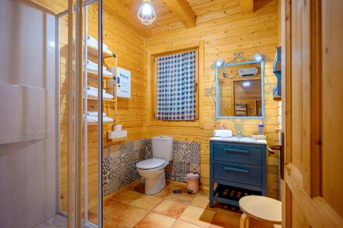 a wooden bathroom with a toilet and a sink at Madera y Miel Casa Rural con niños en Puy du Fou in Guadamur