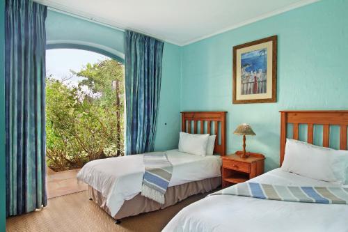 two beds in a room with a window at Caribbean Estates Holiday Resort in Port Edward