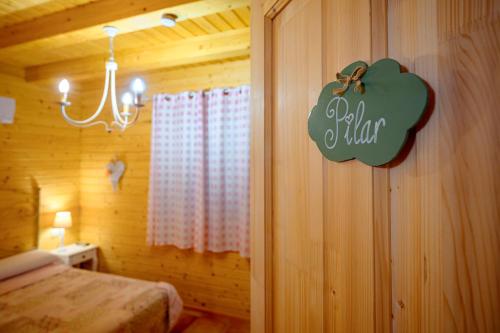 a bedroom with a bed and a sign on the wall at Madera y Miel Casa Rural con niños en Puy du Fou in Guadamur