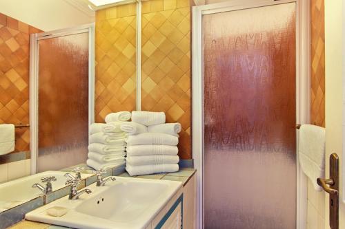 La salle de bains est pourvue d'un lavabo, d'un miroir et de serviettes. dans l'établissement Caribbean Estates Holiday Resort, à Port Edward