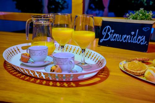 a tray with three glasses of orange juice and biscuits at Madera y Miel Casa Rural con niños en Puy du Fou in Guadamur