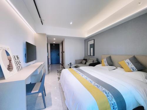 um quarto com uma cama grande e um sofá em Canopy Executive Apartments - Liuxian Cave Headquarters em Shenzhen