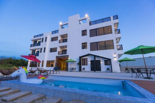 a hotel with a swimming pool and a building at Penghu Swing Sea Homestay in Magong