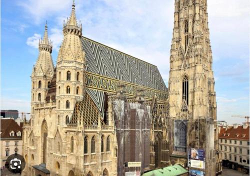 un grand bâtiment avec une tour et une église dans l'établissement Aparthotel Residence, à Vienne