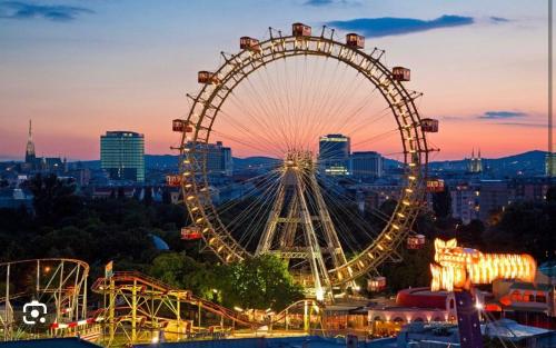 a large ferris wheel in a city at night at Aparthotel Residence in Vienna